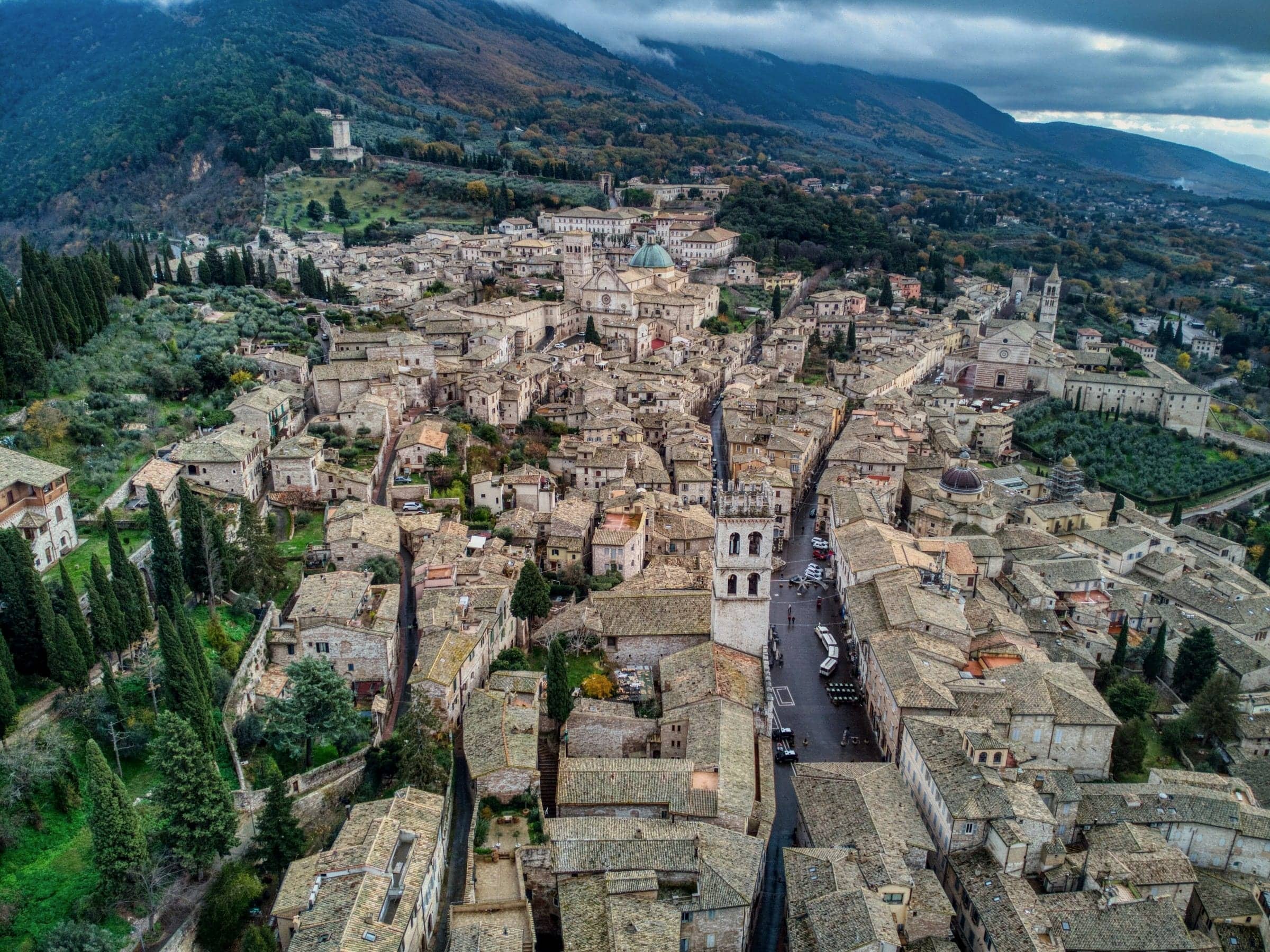 Assisi vista dall'alto: i tetti in pietra, la torre civica e le colline sullo sfondo