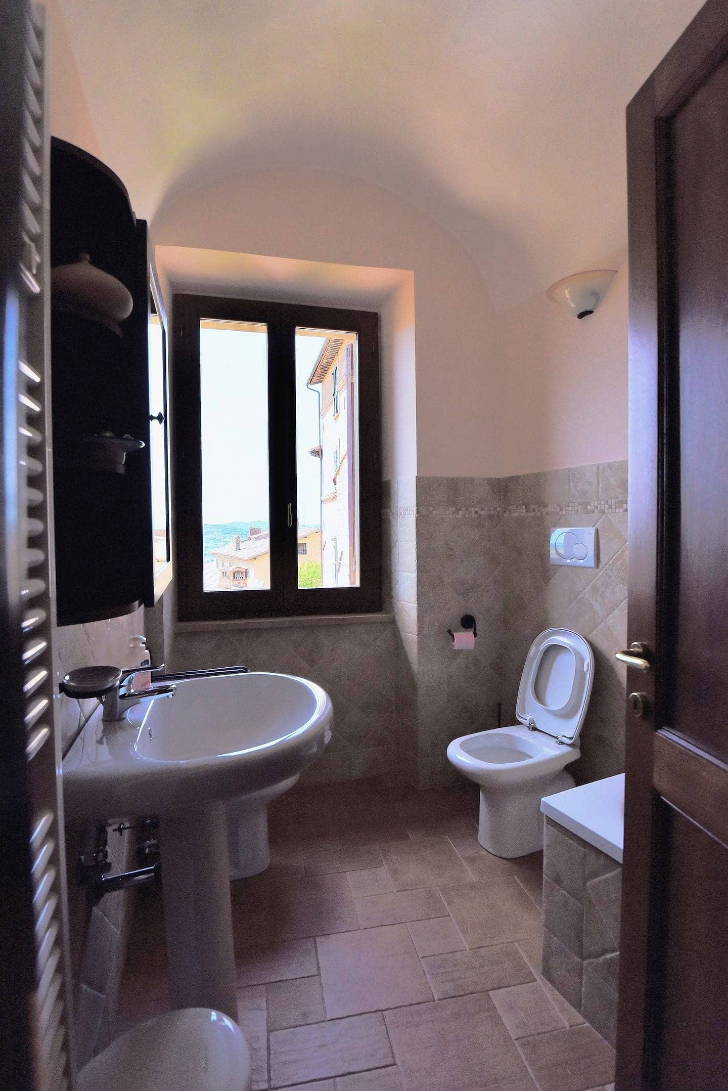 Bagno con volta a vela e una finestra sui tetti del borgo