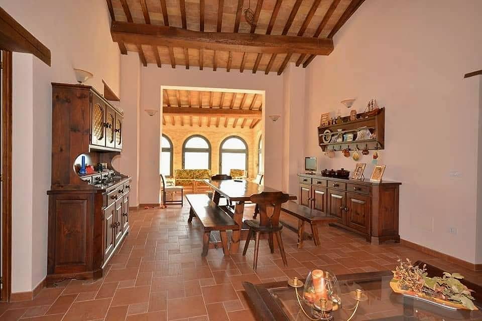 Il salone con il lungo tavolo in legno e le credenze; in fondo si apre la loggia con i suoi archi
